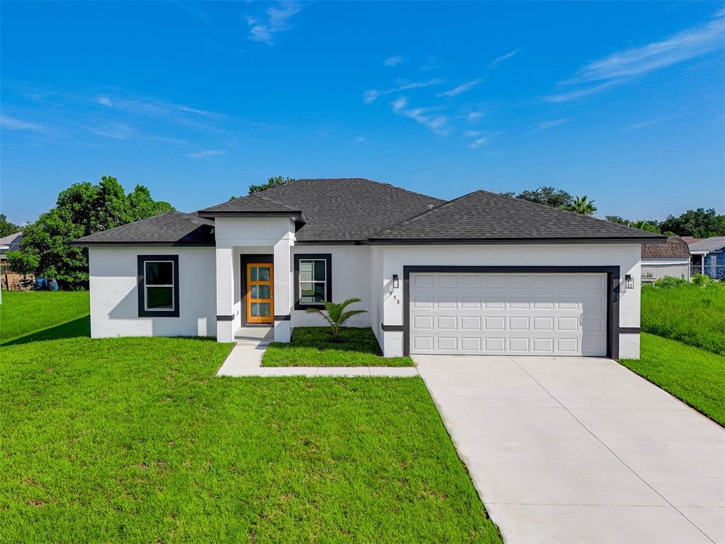 a front view of a house with a yard and garage