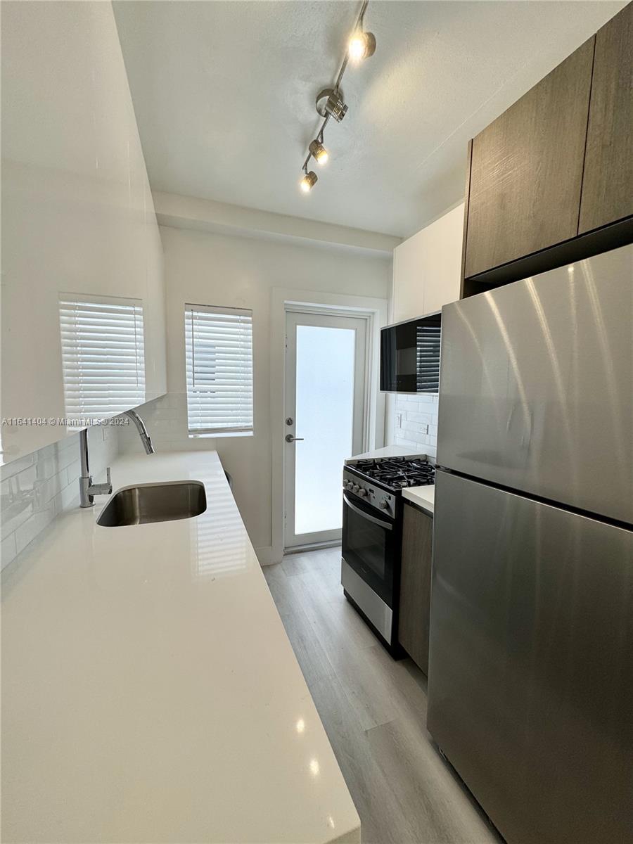 a kitchen with stainless steel appliances a refrigerator sink and stove