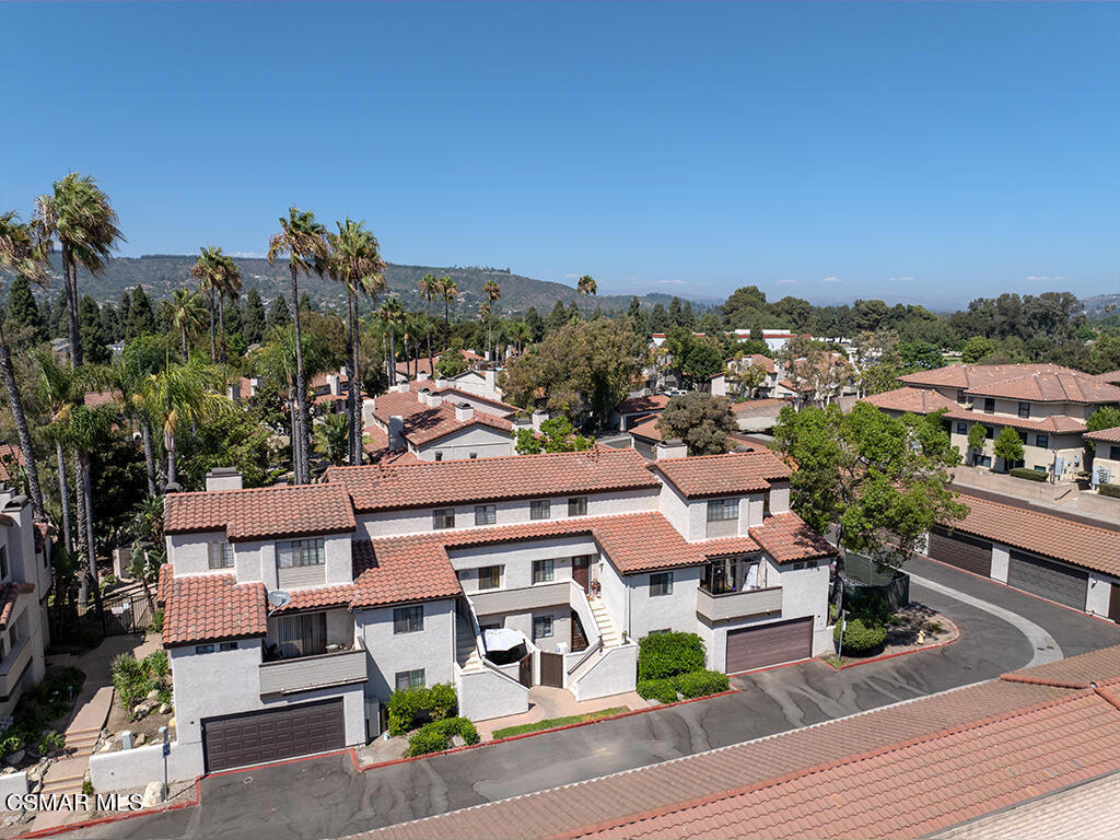 an aerial view of multiple houses with a yard