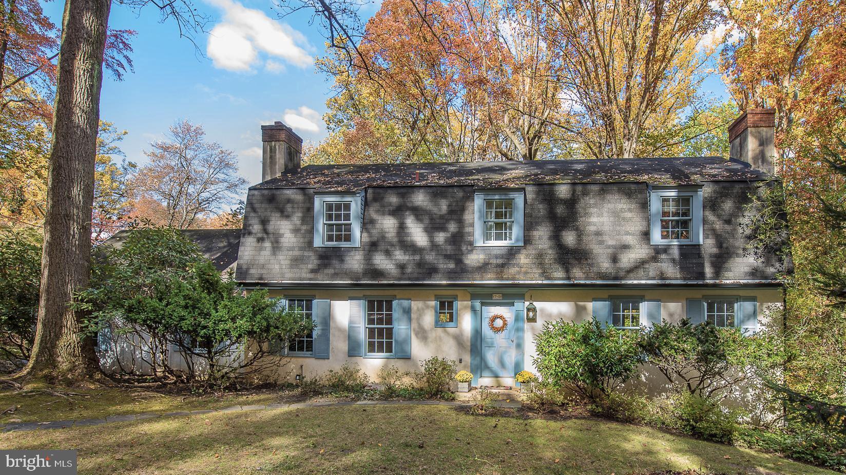 a front view of house with trees around