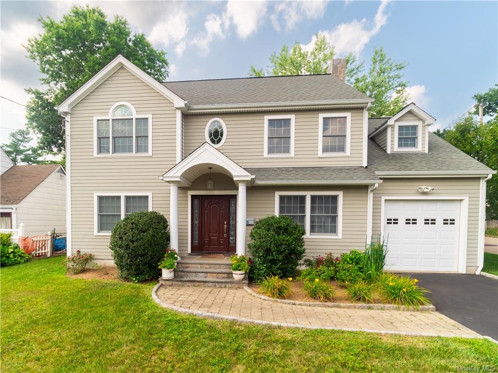 View of front of house with a garage and a front lawn