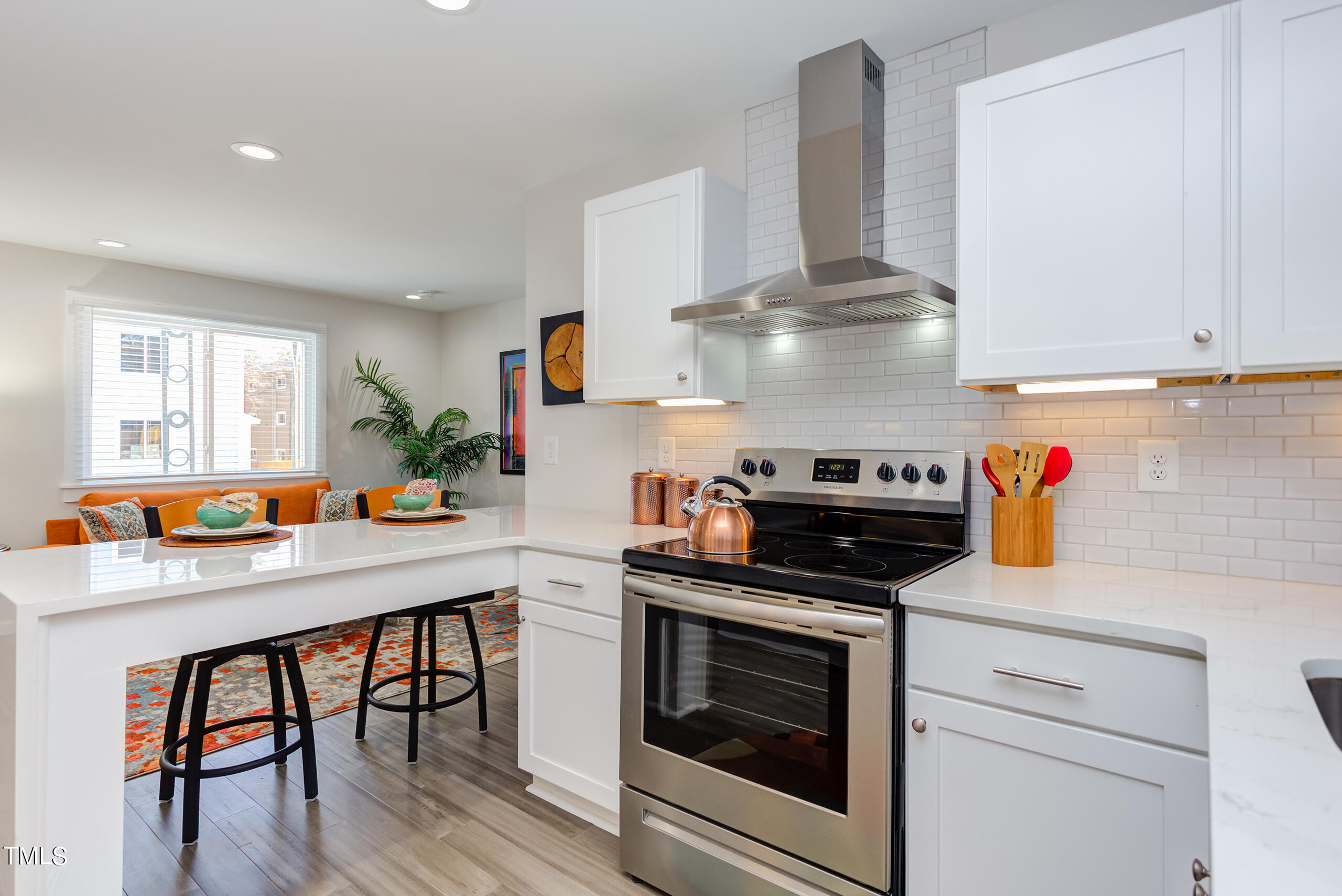 a kitchen with stainless steel appliances granite countertop a stove and white cabinets