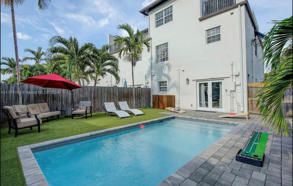 a view of a house with backyard and sitting area