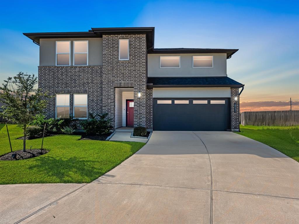 a front view of a house with a yard and garage