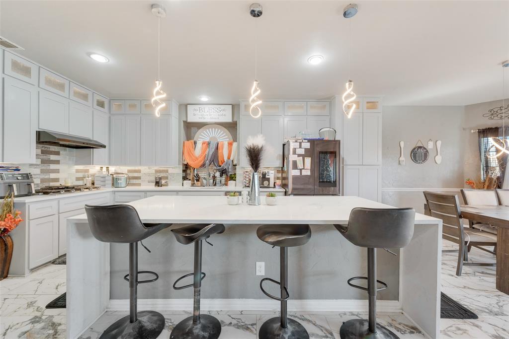 a kitchen with a dining table chairs sink and cabinets