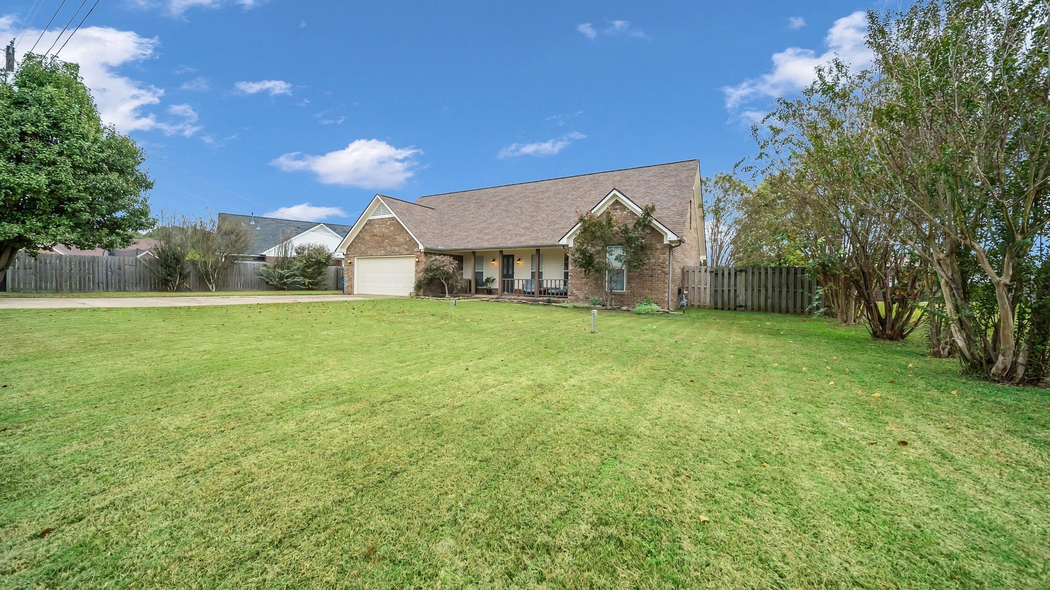 a view of a yard with a house in the background