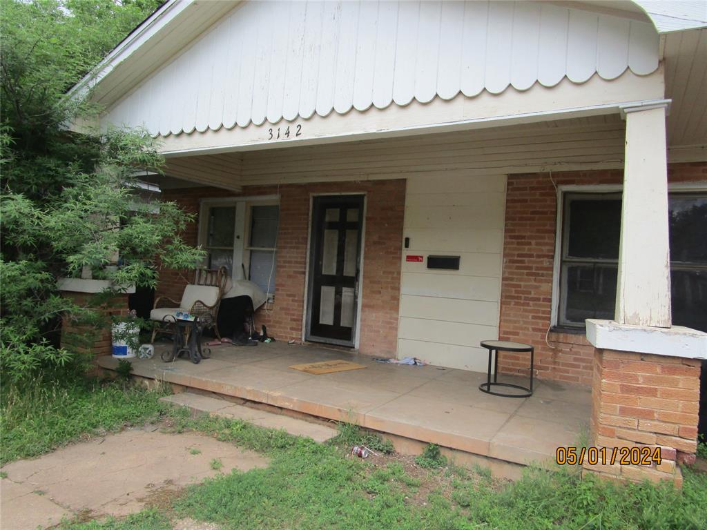 a view of a house with a patio and a yard