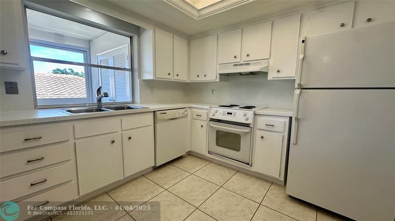 a kitchen with white cabinets and white appliances