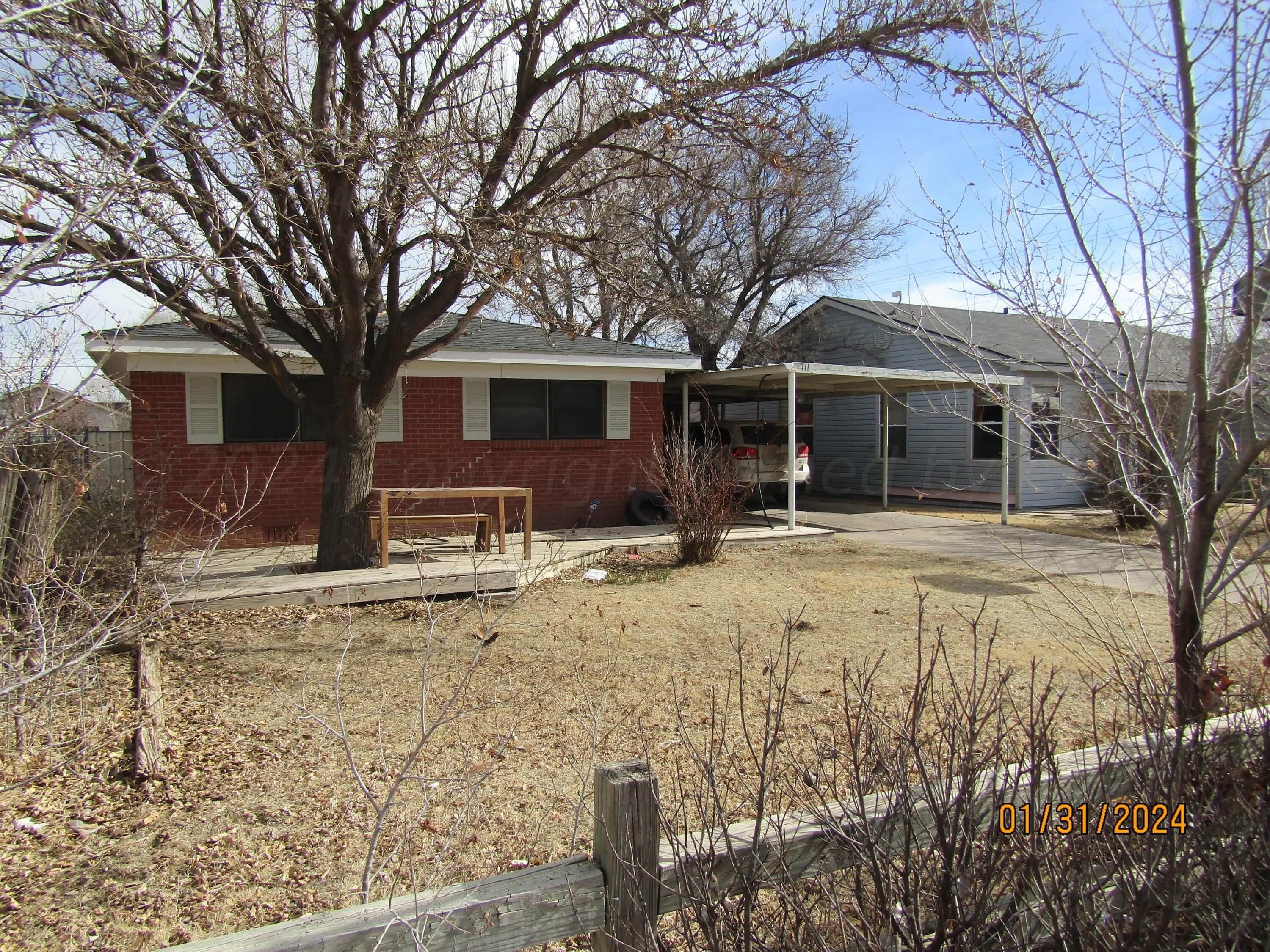 a front view of house with yard covered in snow