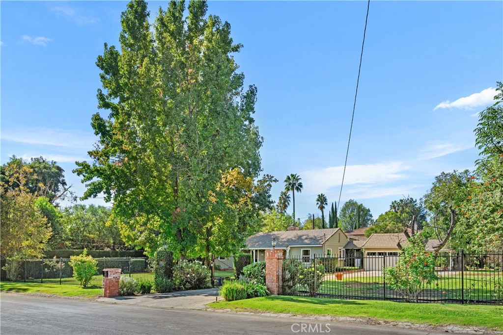 a view of a big house with a big yard and large trees