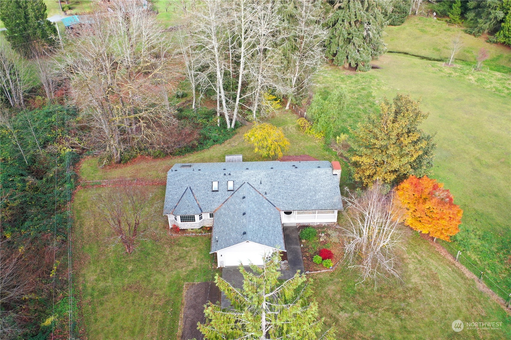 aerial view of a house with a yard and large trees