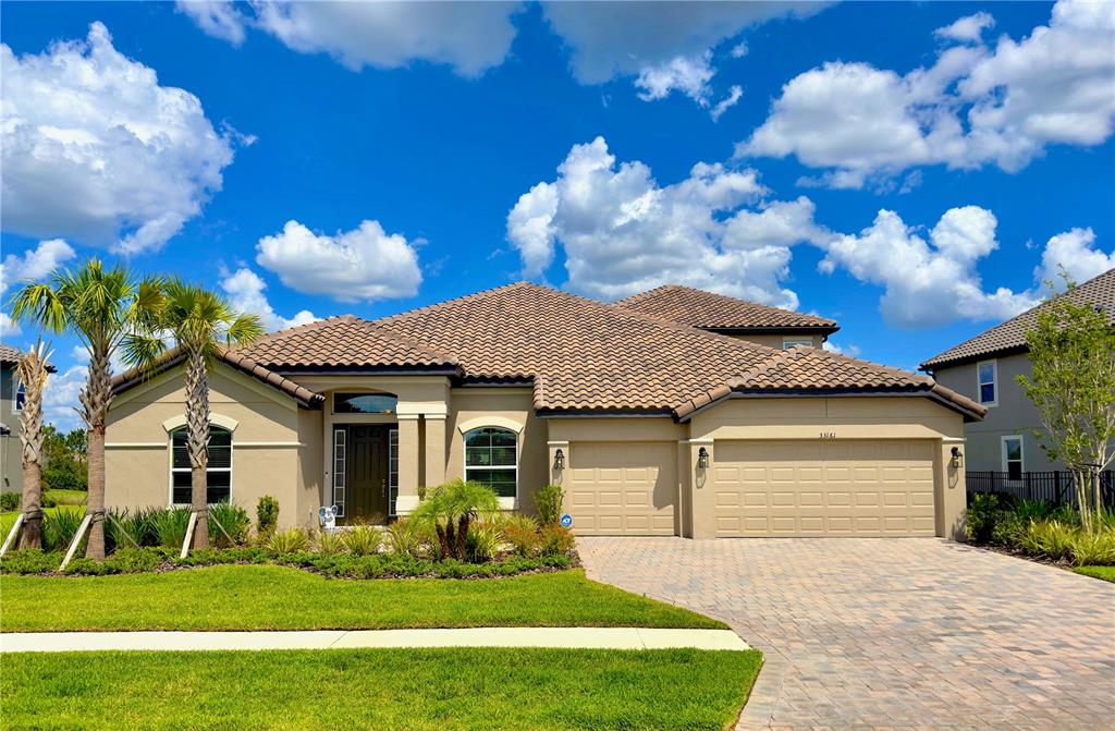 a front view of a house with a garden and yard