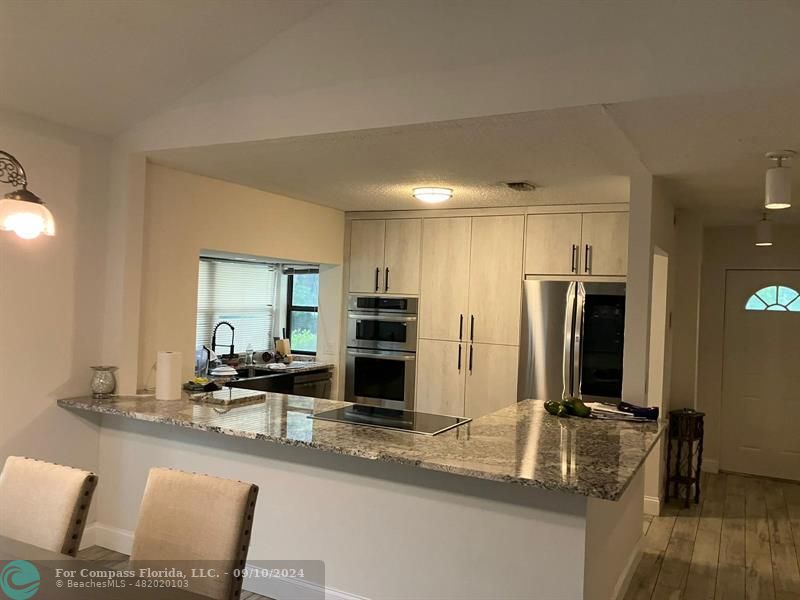 a kitchen with kitchen island a counter top space cabinets and stainless steel appliances