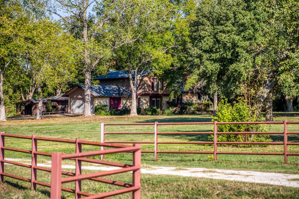 a view of a house in a big yard with large trees