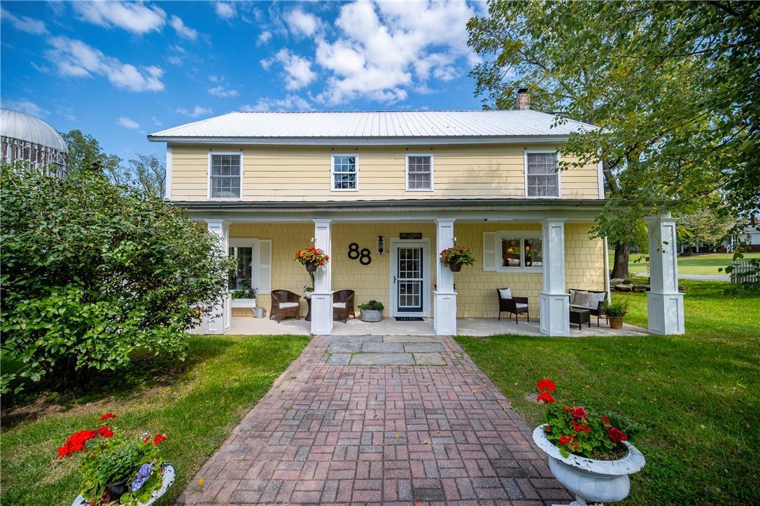 a front view of a house with a porch and a garden