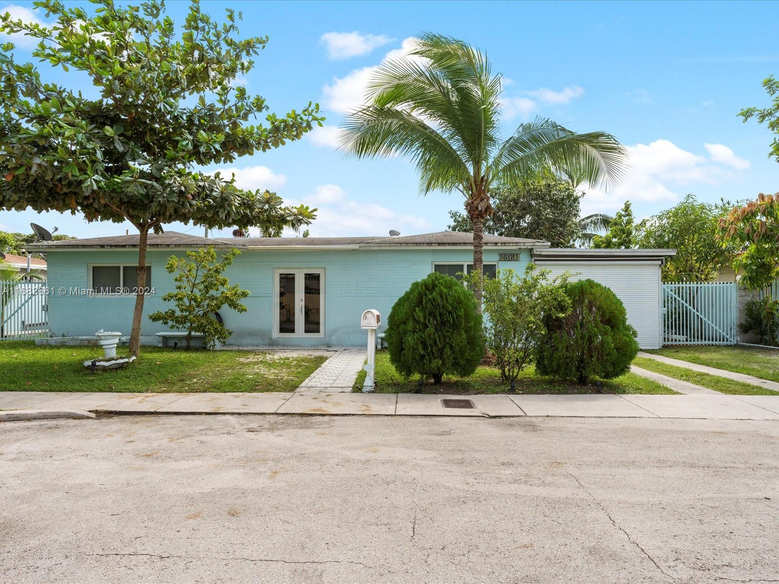 a view of a house with a yard and potted plants