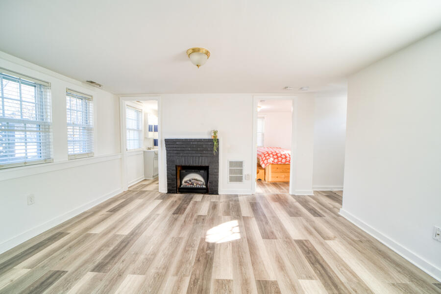 a view of empty room with wooden floor and fireplace