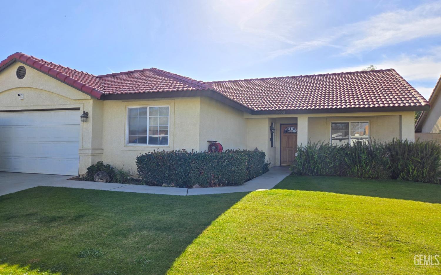 a front view of a house with a garden and yard