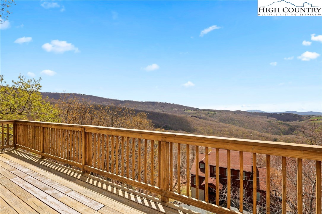 a view of a balcony with wooden floor and fence