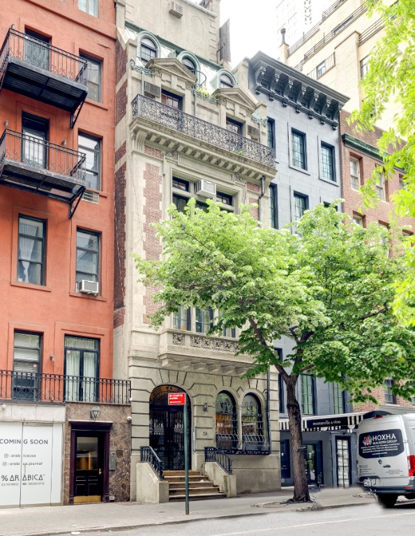 a front view of a building and trees