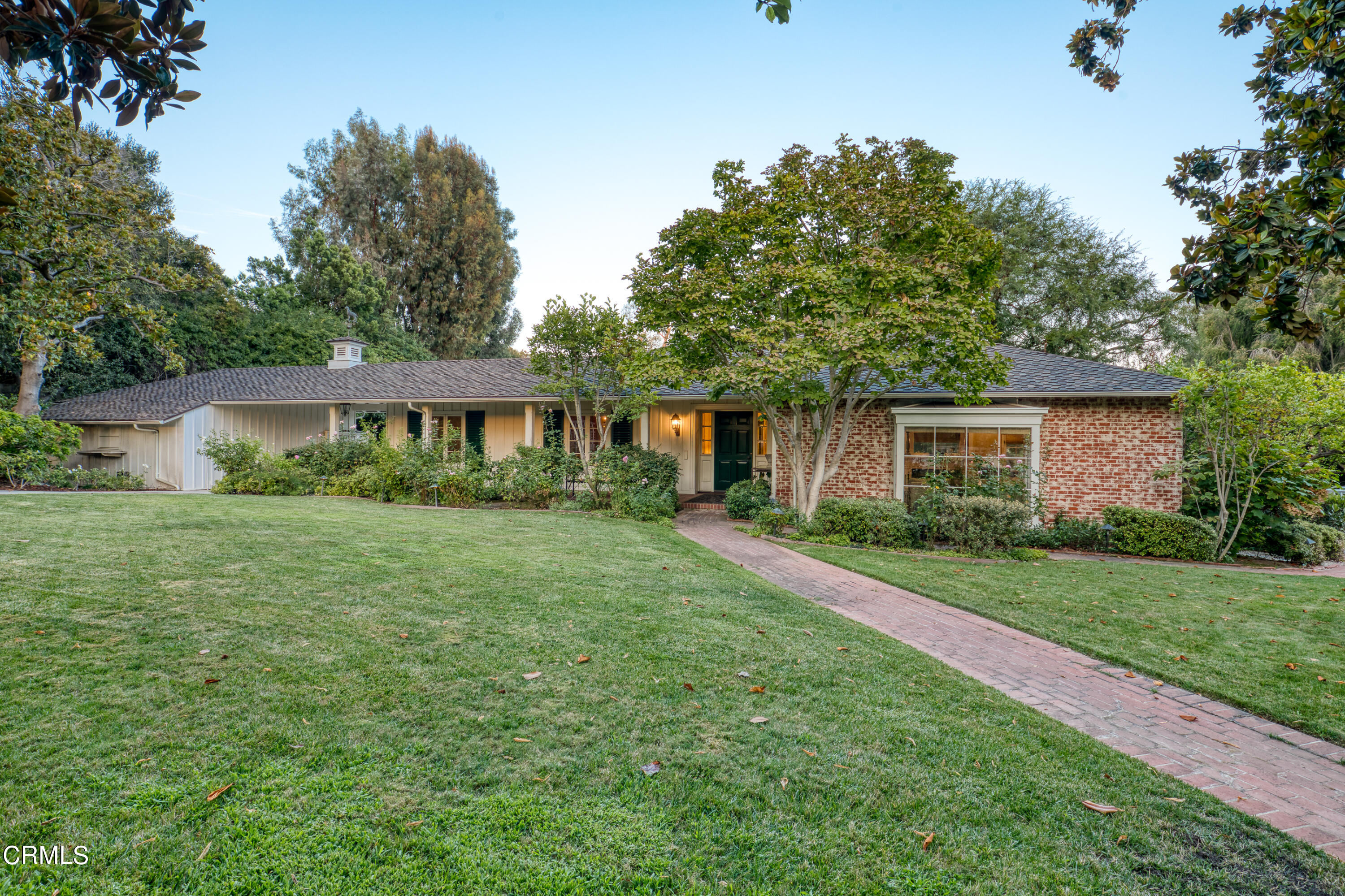 a front view of a house with a yard and trees