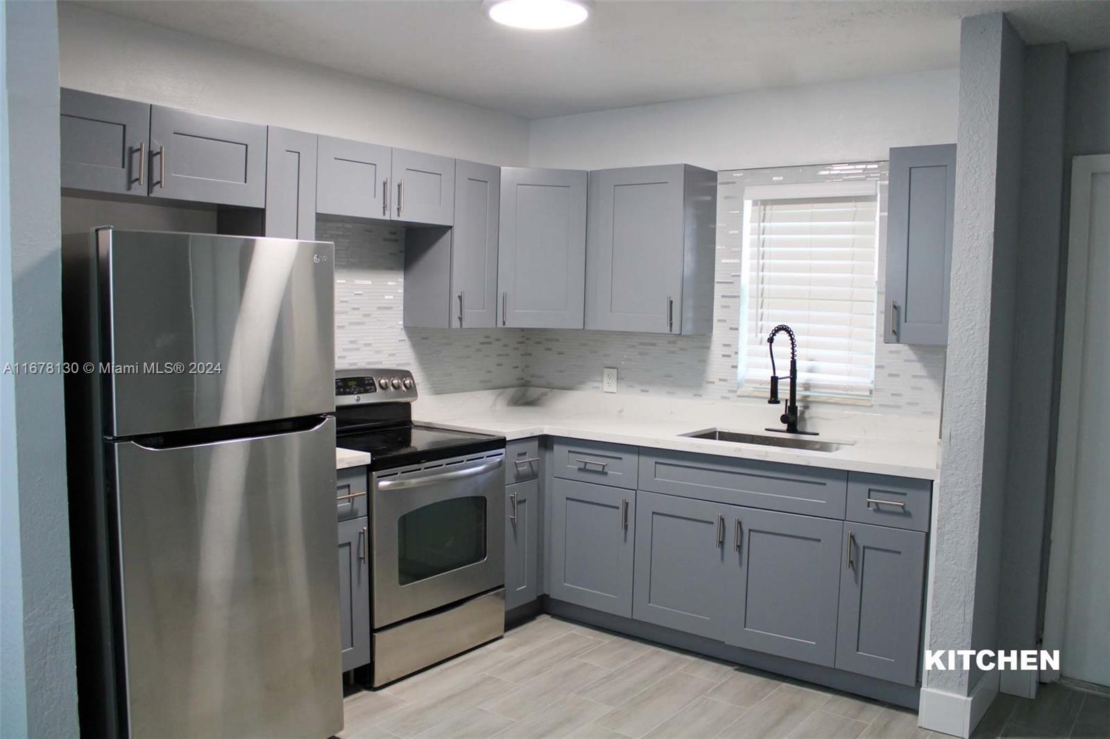 a kitchen with stainless steel appliances a refrigerator sink and cabinets