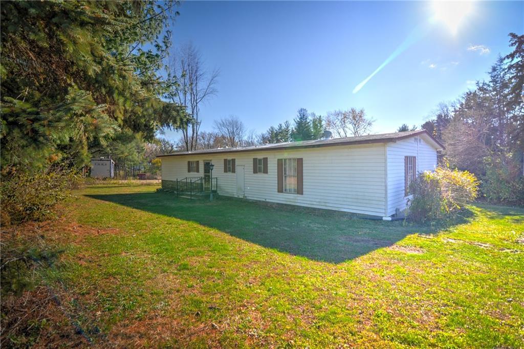 a view of a house with backyard and a tree