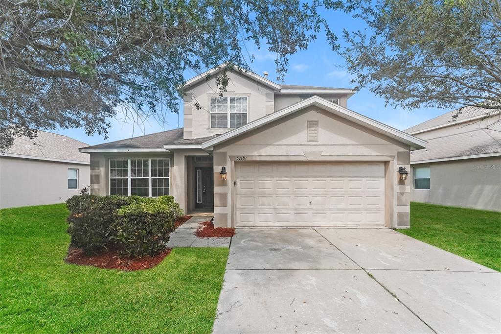 a front view of a house with a yard and garage