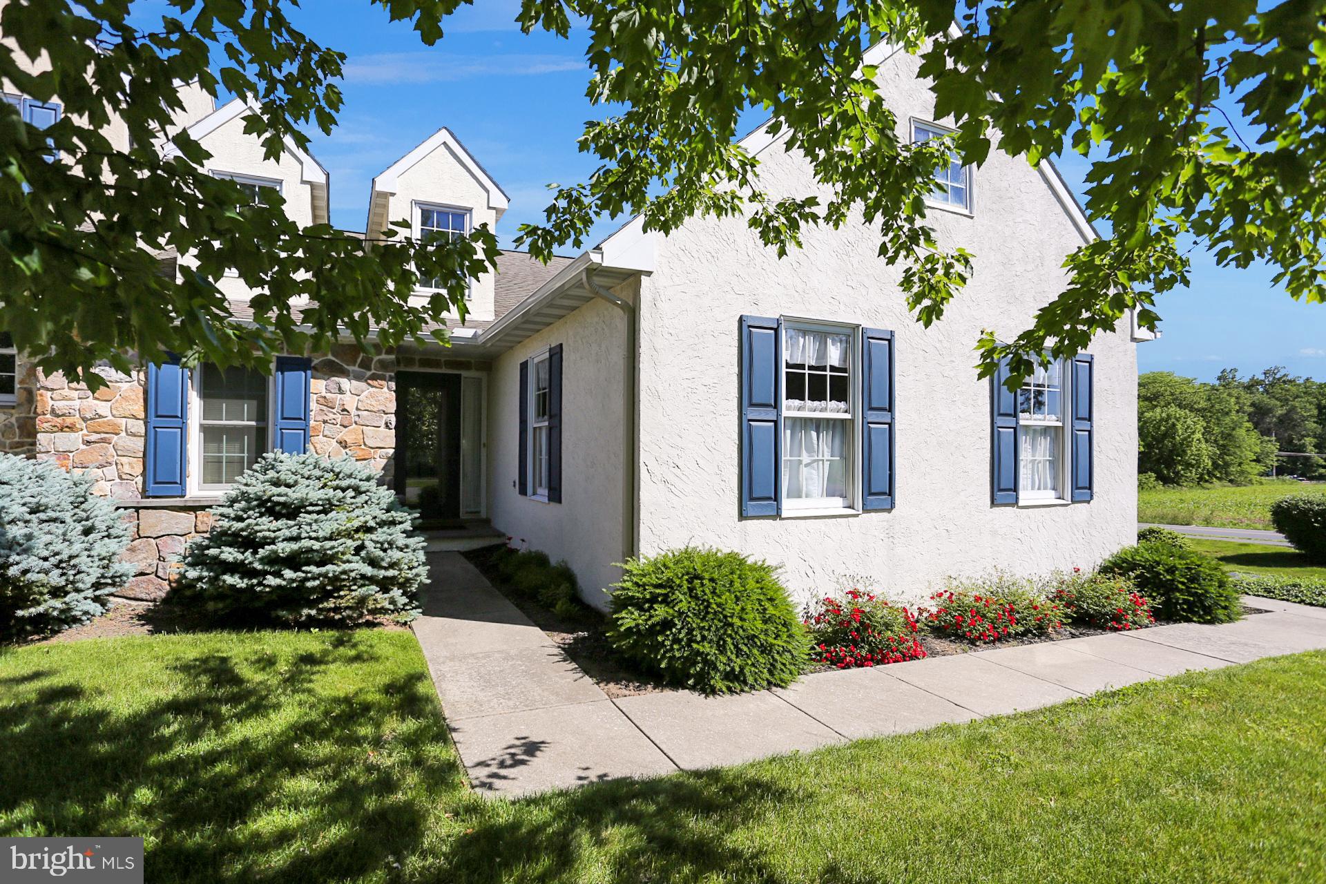 a front view of a house with a yard and potted plants