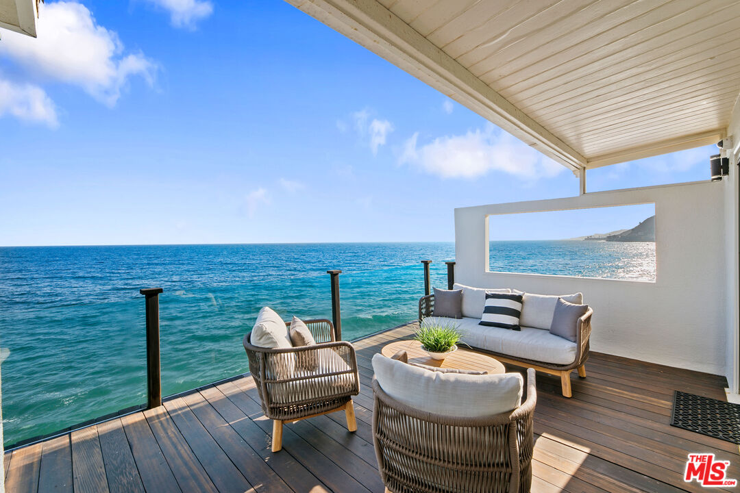 a balcony with table and chairs