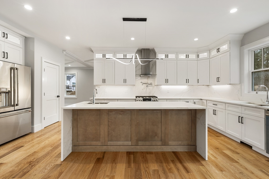 a large kitchen with cabinets and wooden floor