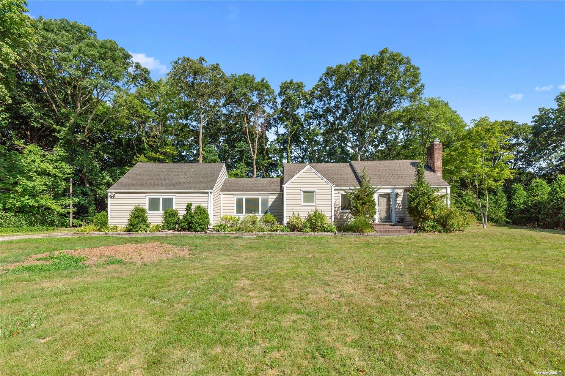 a front view of a house with a yard and trees