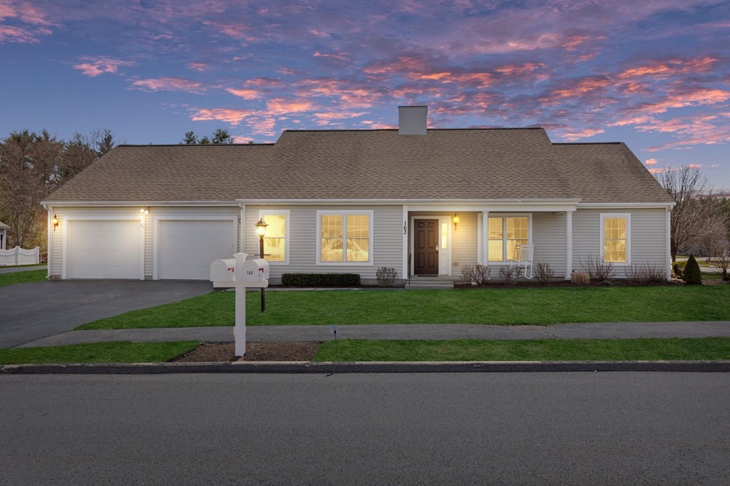 a front view of a house with a yard and a garage