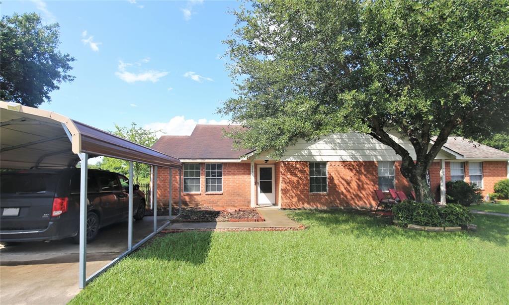 a view of a house with backyard and a tree