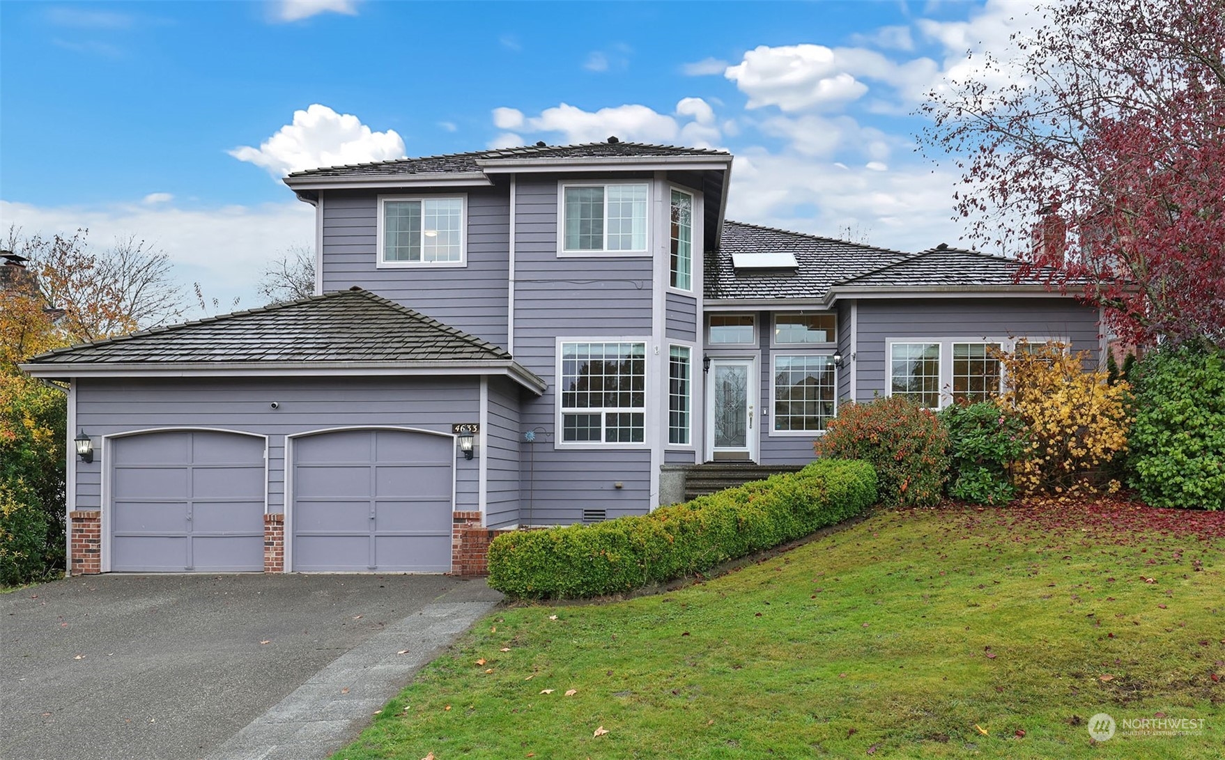 a front view of a house with a garden and garage