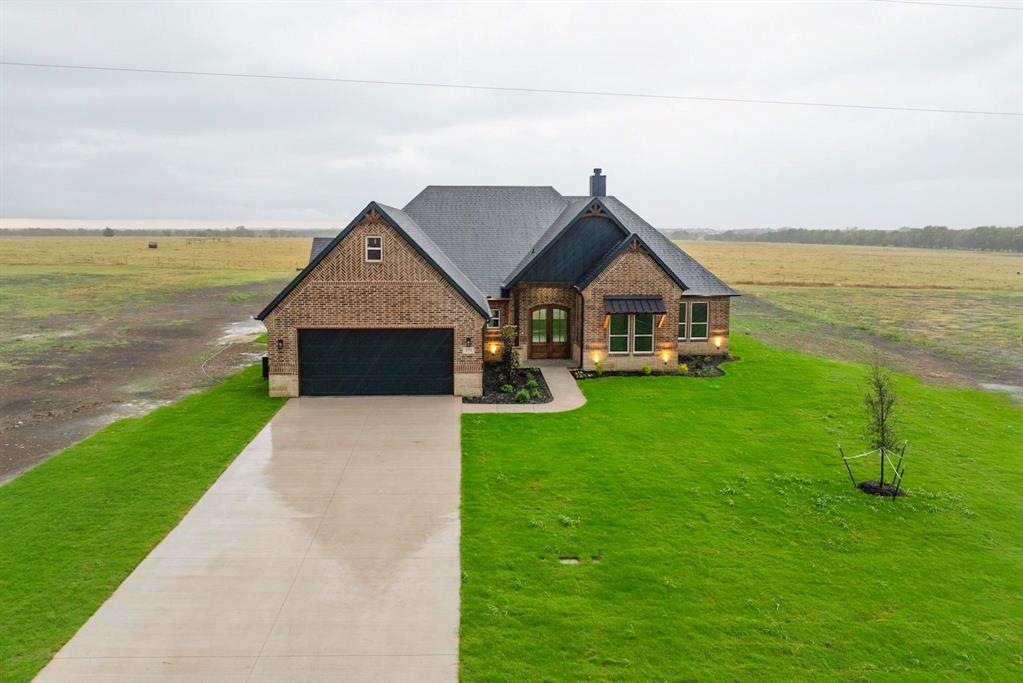 a front view of a house with a yard and ocean view