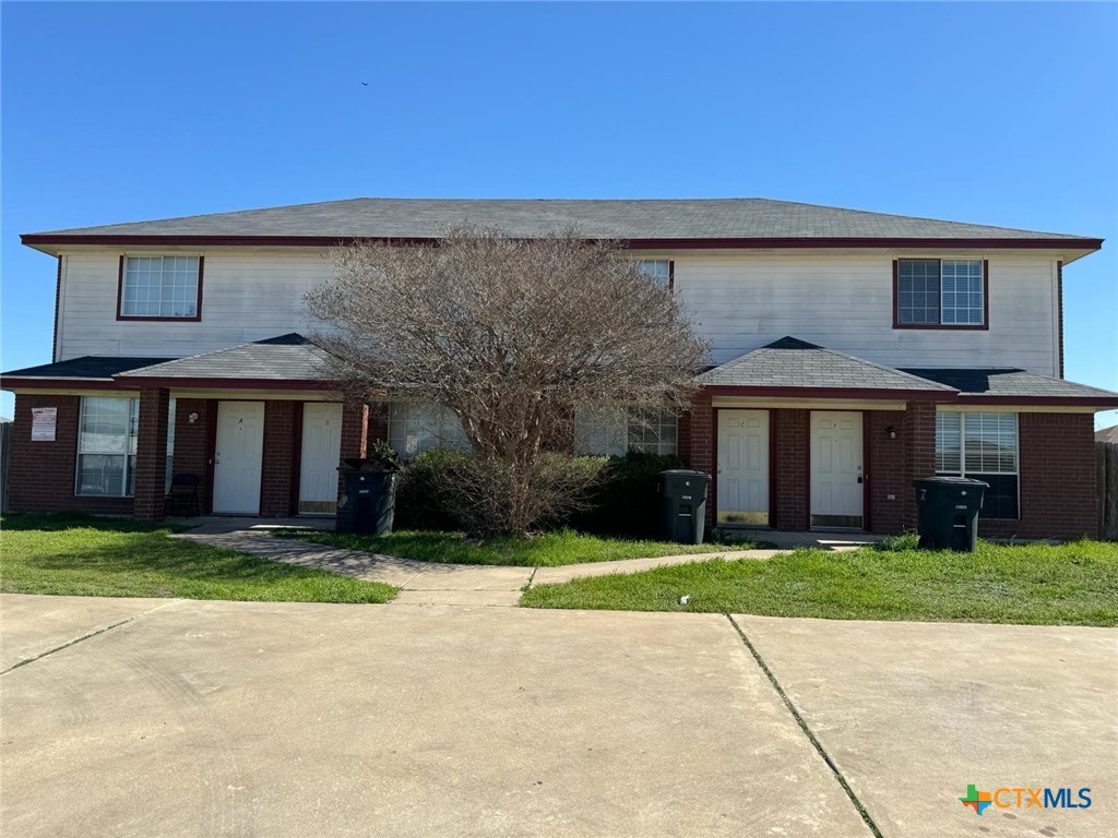 a view of a brick house with a yard