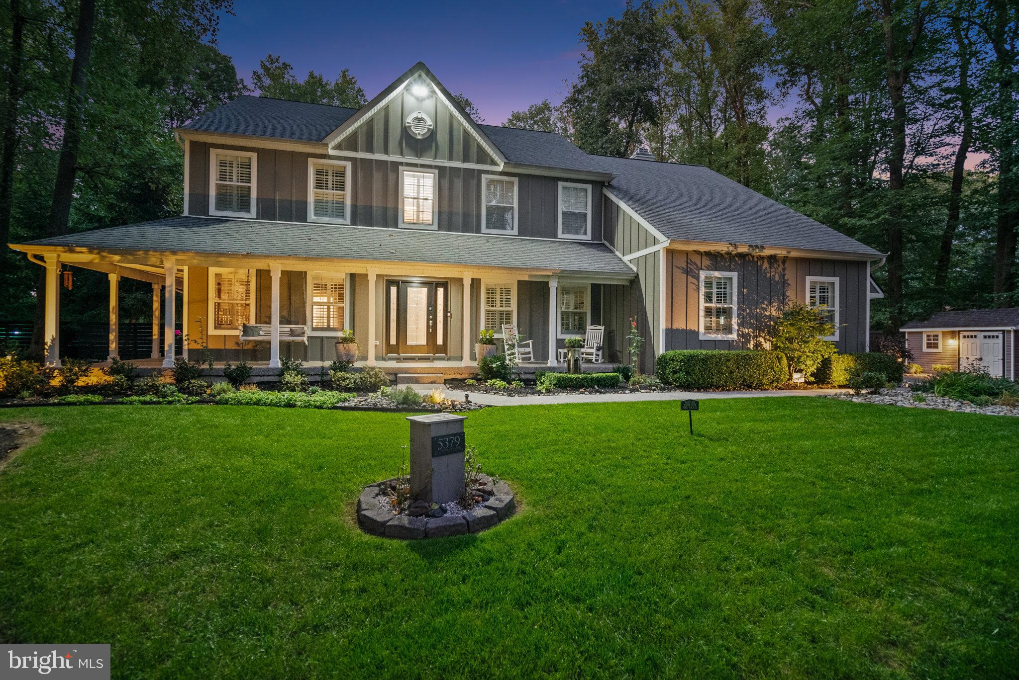 a front view of a house with a yard and green space