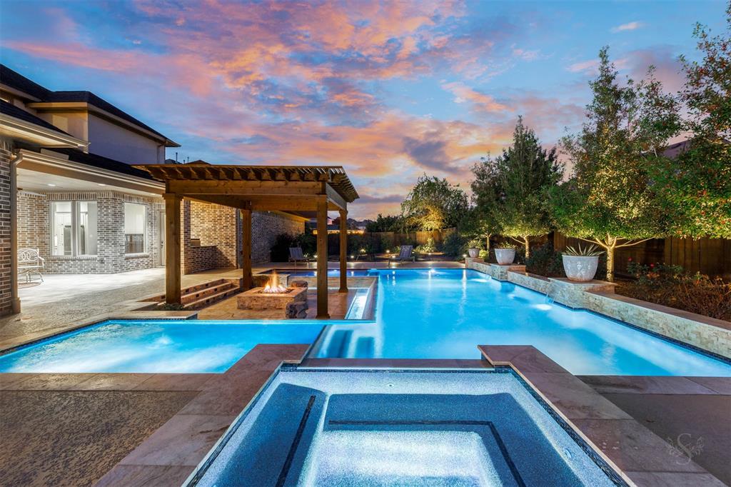 Step into this extraordinary outdoor oasis! As the sun sets, the back yard showplace comes alive with glowing accent lights (up lights & down lights), transforming the space into a breathtaking retreat. The expansive backyard features a shimmering pool with tanning ledges and fountains, relaxing spa, a covered patio with an outdoor kitchen and a pergola-shaded sunken patio with a cozy fire pit. Surrounded by lush landscaping, there's even green space for pets to play. This is outdoor living at it's finest!