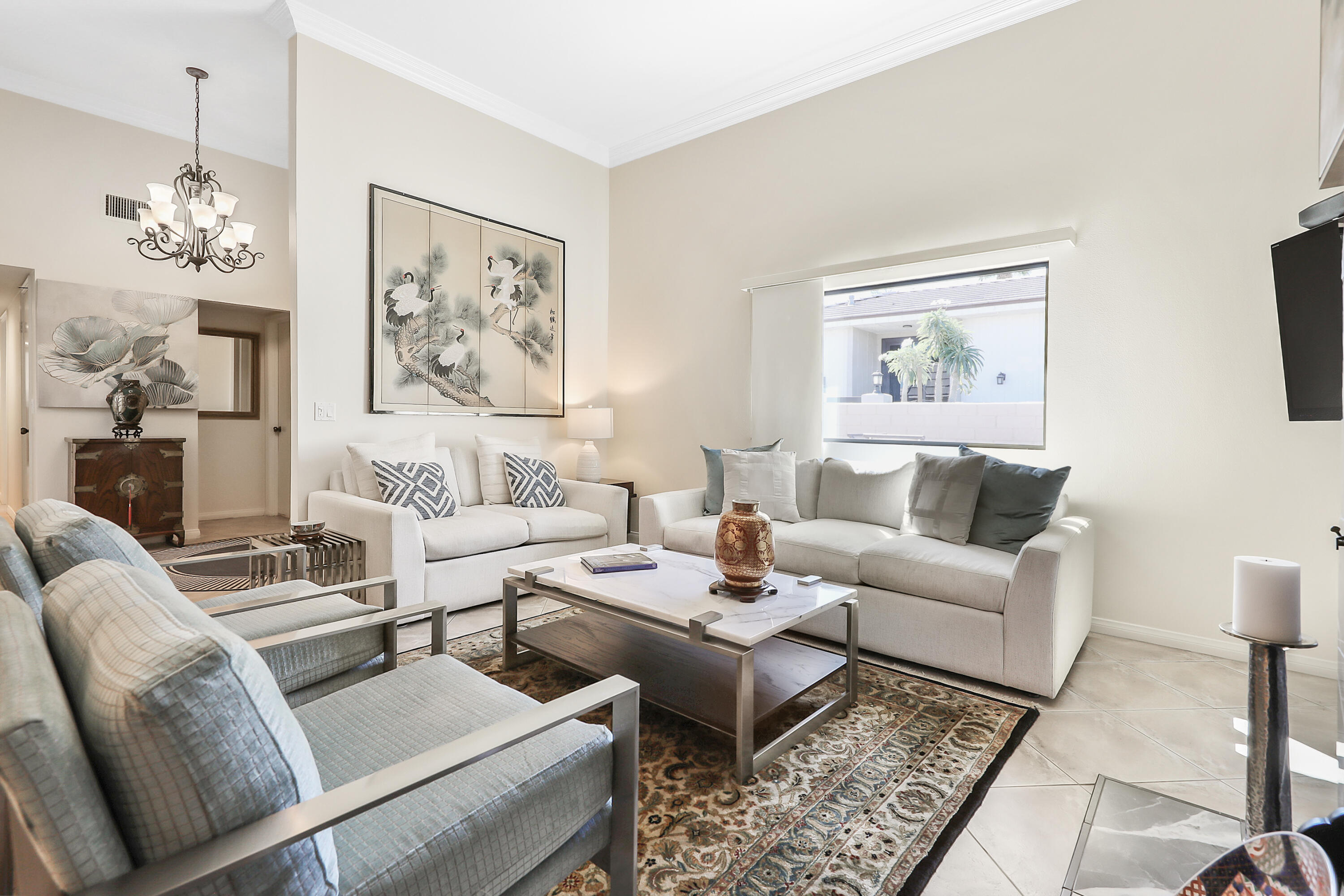 a living room with furniture and a painting on the wall