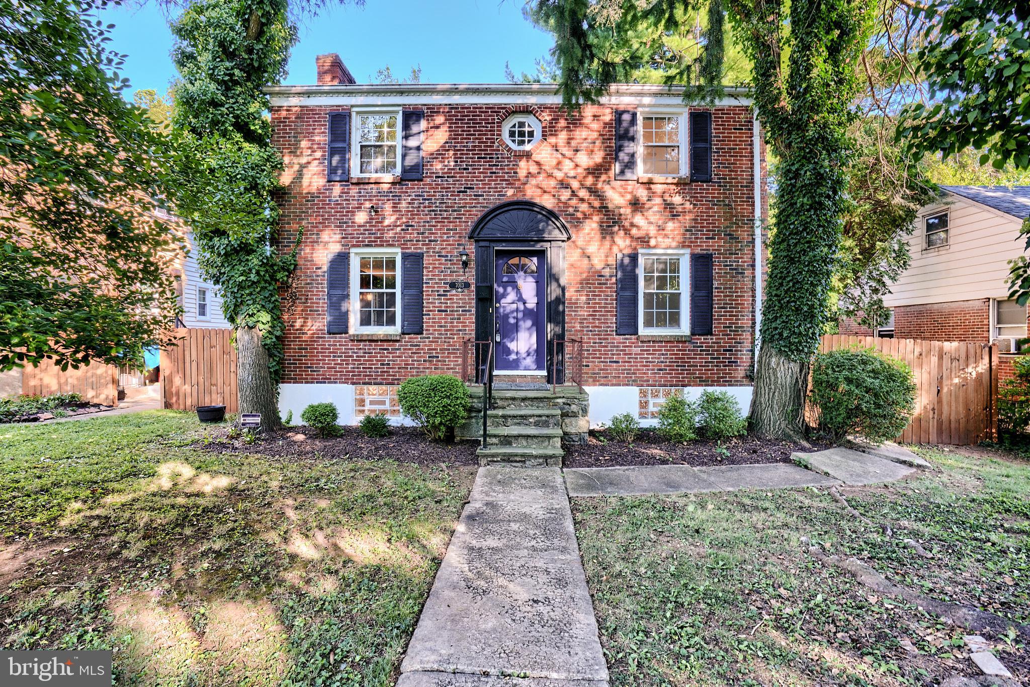 front view of a brick house with a yard