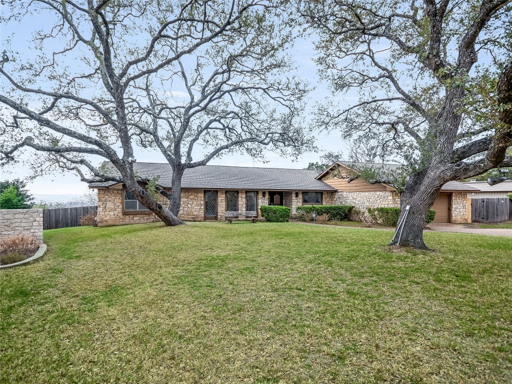 a front view of a house with yard and green space