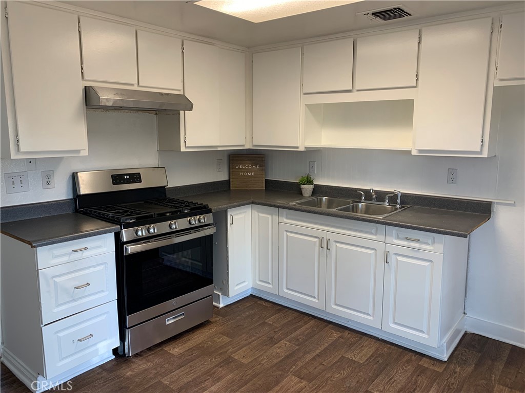 a kitchen with granite countertop white cabinets and appliances