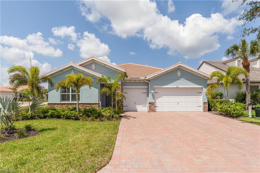 View of front of home with a garage and a front lawn