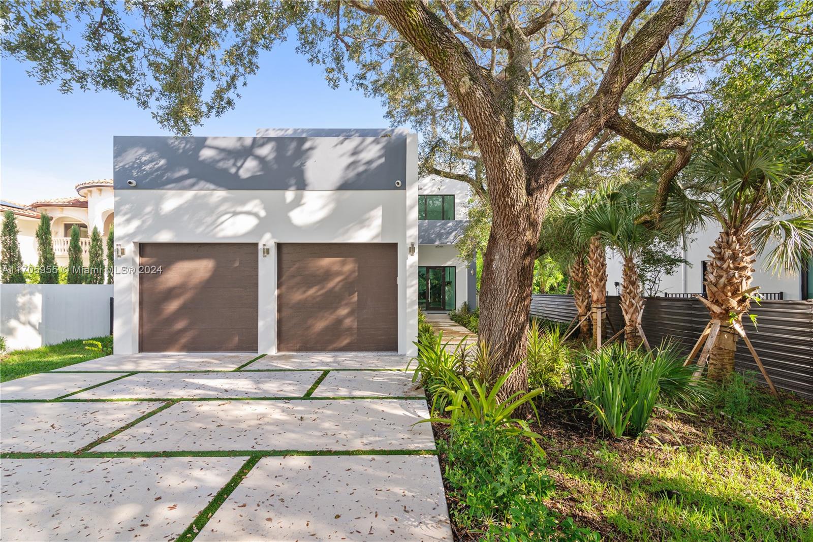 a front view of a house with a yard garage and outdoor seating