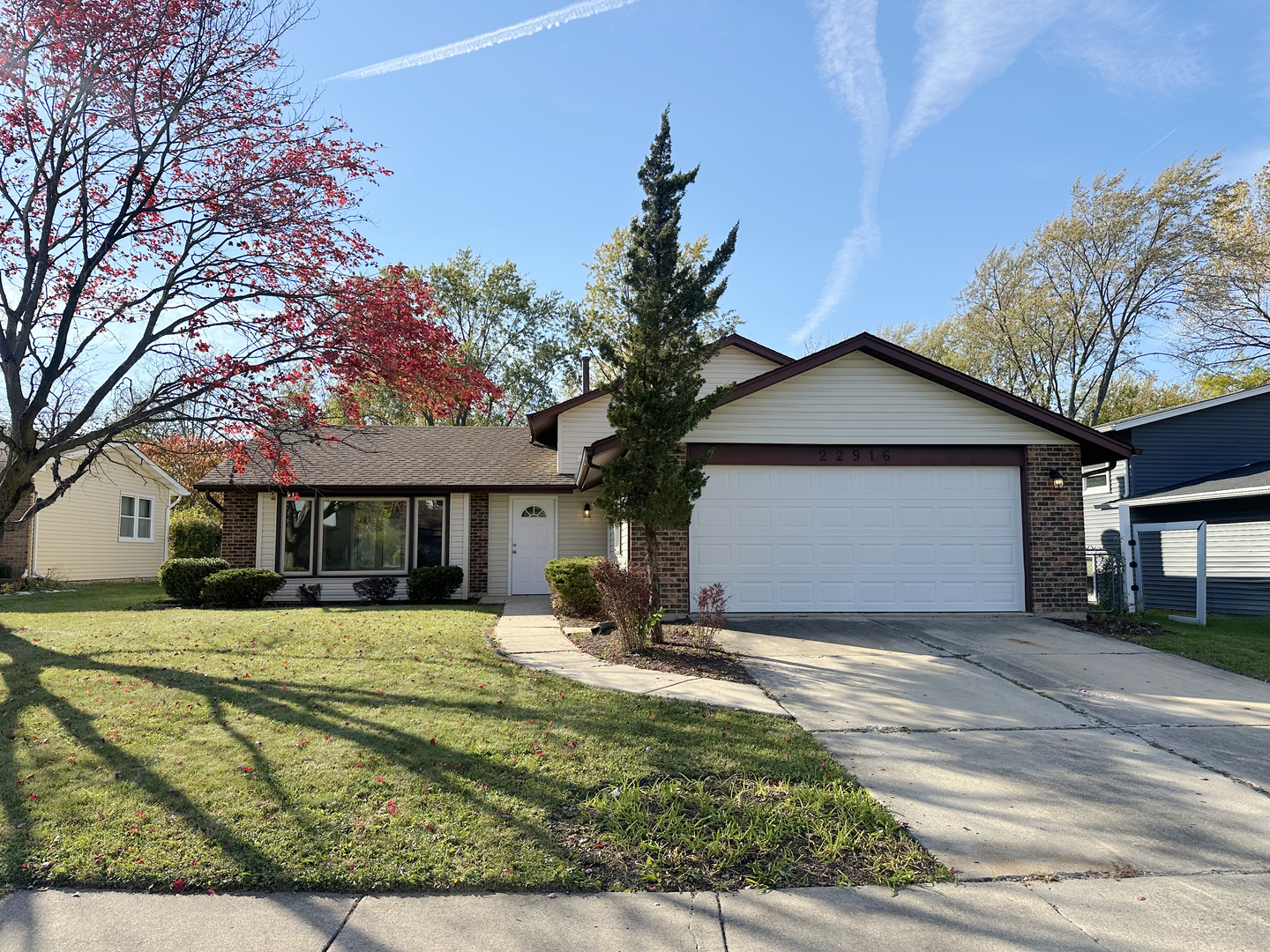 a front view of house with yard and trees around