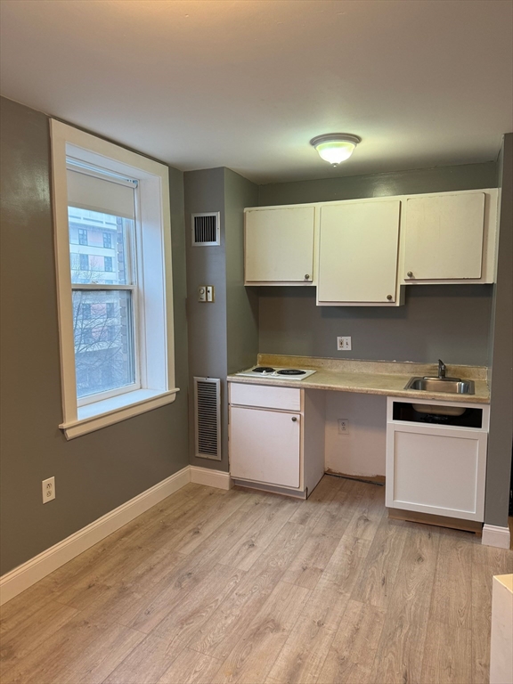 a kitchen with granite countertop a stove a sink and a refrigerator