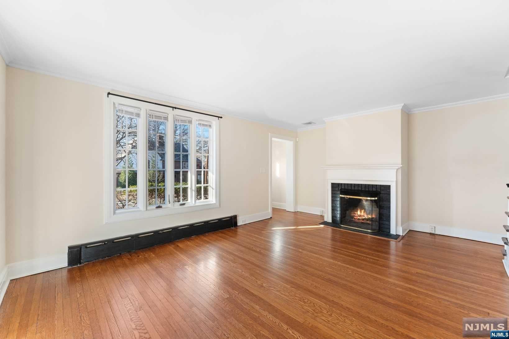 a view of empty room with wooden floor and fireplace