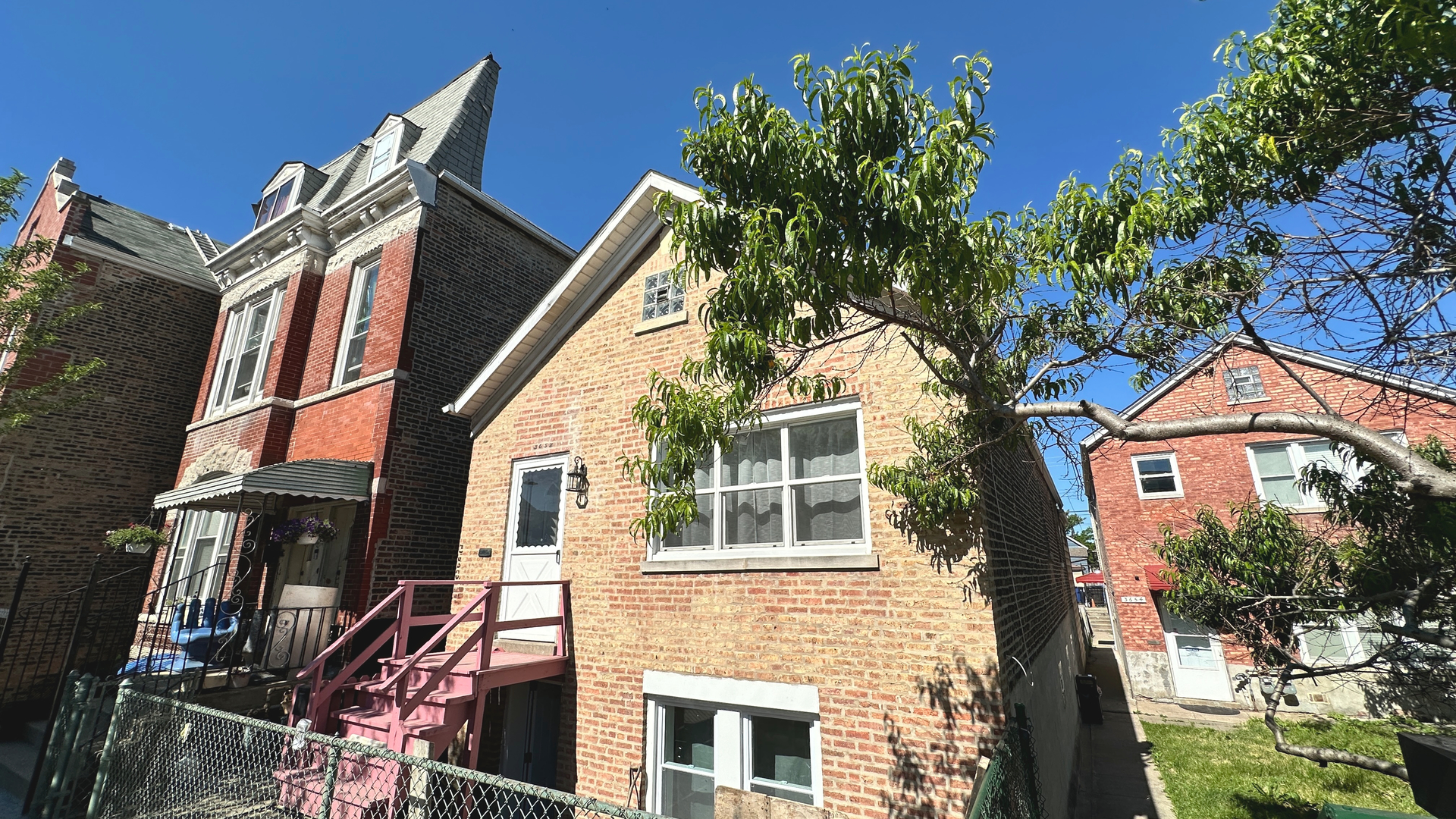 a front view of a house with a tree