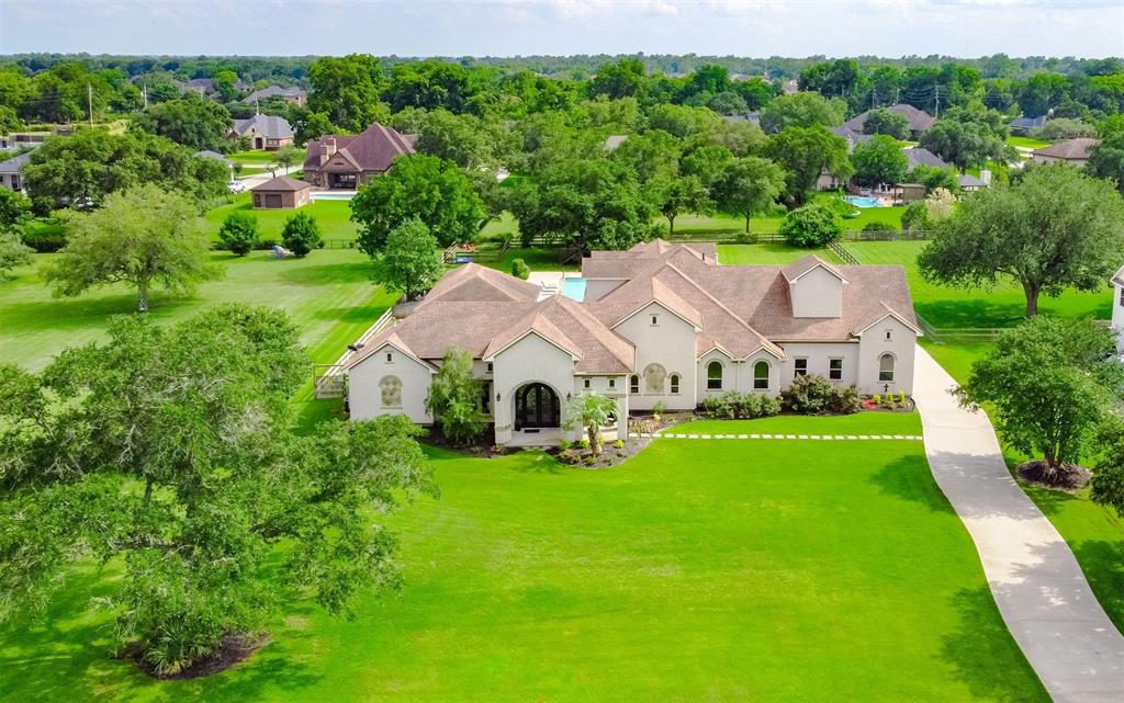 an aerial view of a house with yard and green space